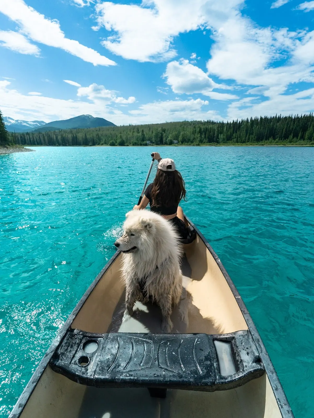 Saiko and Marion paddling a canoe on a turquoise lake