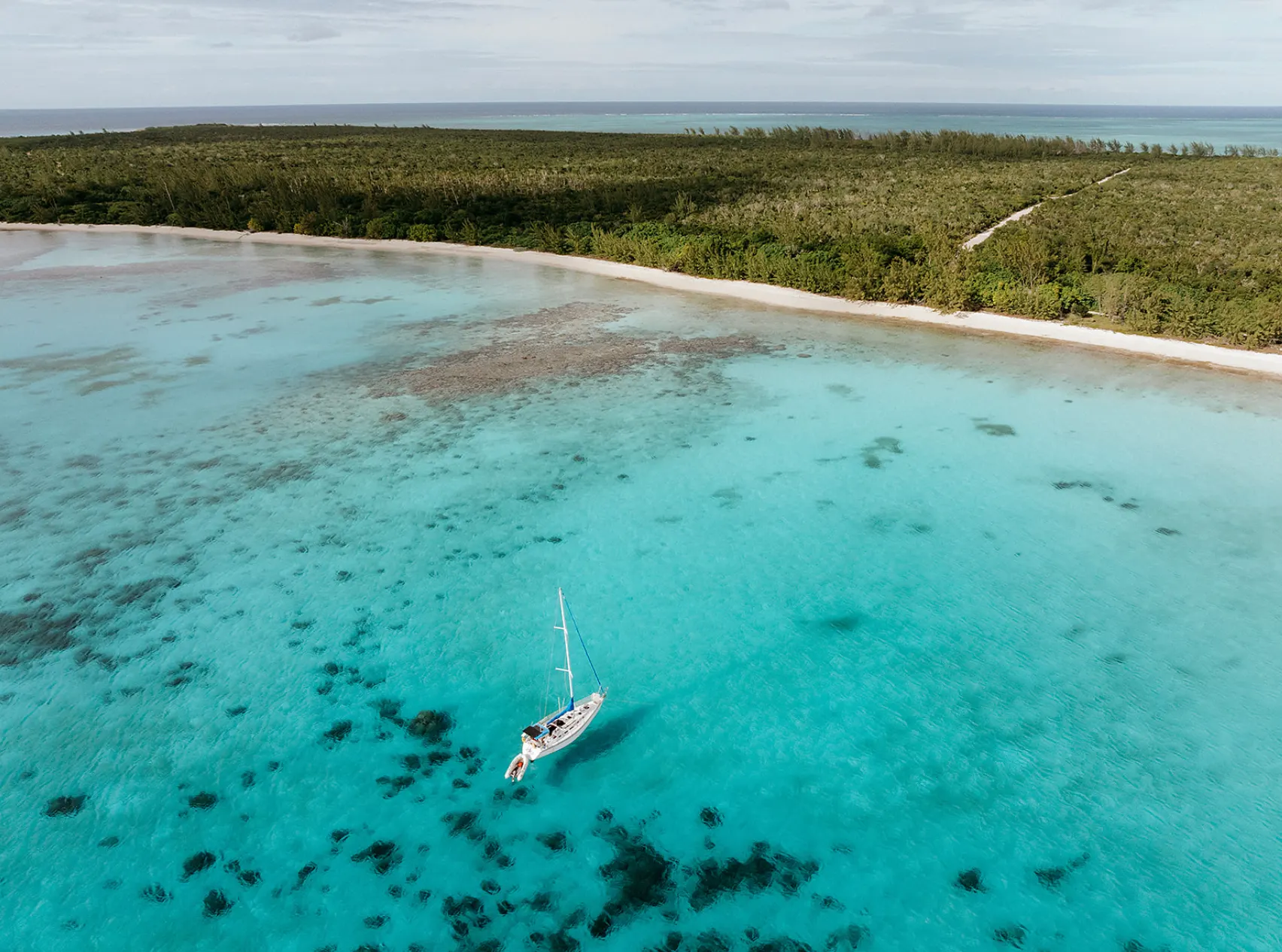 Aerial view of a sailboat in turquoise Caribbean water